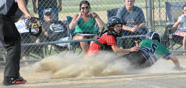 Ethan Strunk, right, of the Fayetteville Rockets slides into home plate during action July 12, 2023, against the New Richmond River Rats in the Class B Junior East Region Knothole Baseball playoffs at Mt. Orab.