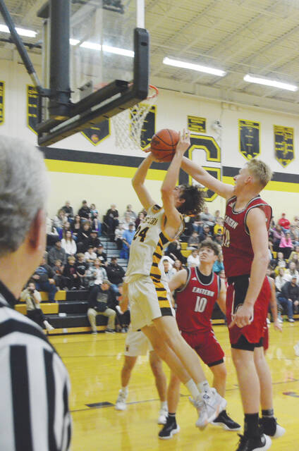 Western Browns William Stewart goes up for a shot while Easterns Luke Haney attempts a block during the Brown County Holiday Tournament varsity boys championship game on Dec. 29. Photo by Wade Linville