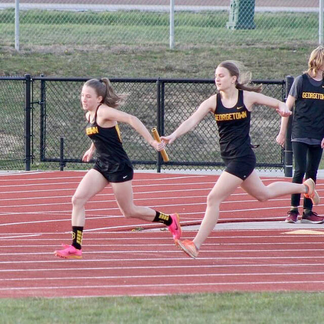 Georgetowns Elizabeth Cahall takes a hand-off from teammate Evelyn Cahall during the Georgetown Season Kickoff track and field meet held March 26.